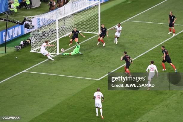 England's forward Harry Kane kicks the ball as Croatia's goalkeeper Danijel Subasic and Croatia's defender Domagoj Vida go to block it during the...