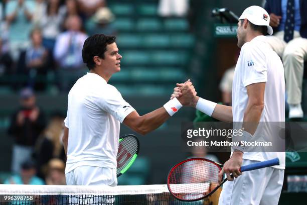 Milos Raonic of Canada and John Isner of the United States embrace at the net following their Men's Singles Quarter-Finals match on day nine of the...
