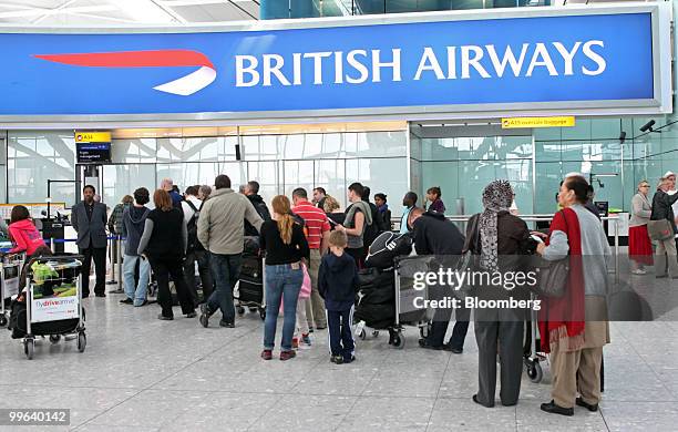 Airline passengers wait at the British Airways check-in desk in Terminal 5 at Heathrow airport in London, U.K., on Monday, May 17, 2010. British...