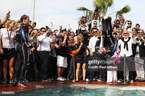 Mark Webber of Australia and Red Bull Racing celebrates by doing a back flip into the Red Bull Energy Station swimming pool after winning the Monaco...