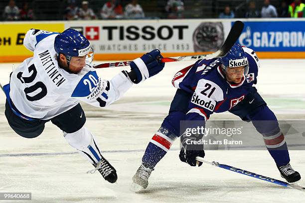 Antti Miettinen of Finland is challenged by Marek Zagrapan of Slovakia during the IIHF World Championship qualification round match between Finland...