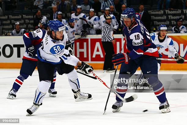 Juhamatti Aaltonen of Finland shoots on goal next to Tomas Starosta of Slovakia during the IIHF World Championship qualification round match between...