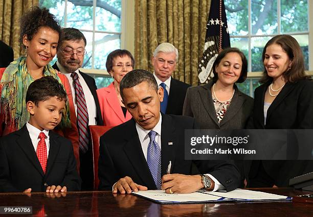 President Barack Obama signs the Daniel Pearl Freedom of Press Act while widow Mariane Pearl and son Adam Daniel Pearl , stand nearby on May 17, 2010...