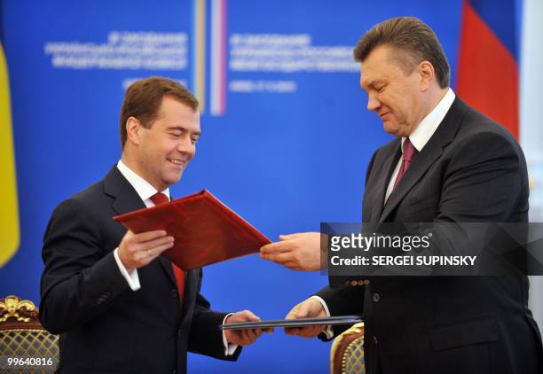 Ukrainie's President Viktor Yanukovych and his Russian counterpart Dmitry Medvedev exchange folders after signing documents in Kiev on May 17, 2010....