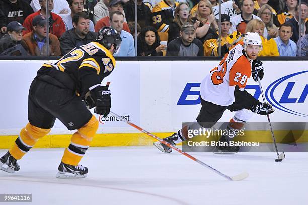 Claude Giroux of the Philadelphia Flyers skates with the puck against Trent Whitfield of the Boston Bruins in Game Seven of the Eastern Conference...