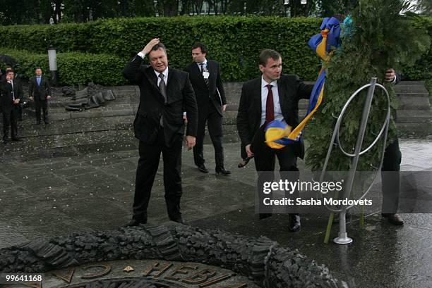 President of Ukraine Viktor Yanukovych adjusts his hair after a wreath fell on him during a ceremony to mark the 1932-1933 Soviet famine known as...