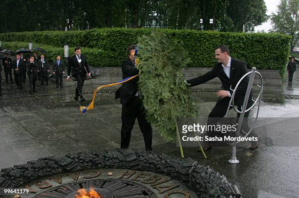 Security guard attempts to prevent a wreath falling towards the President of Ukraine Viktor Yanukovych during a ceremony to mark the 1932-1933 Soviet...