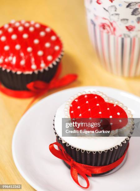 delicious cupcake with red heart frosting - red delicious stockfoto's en -beelden