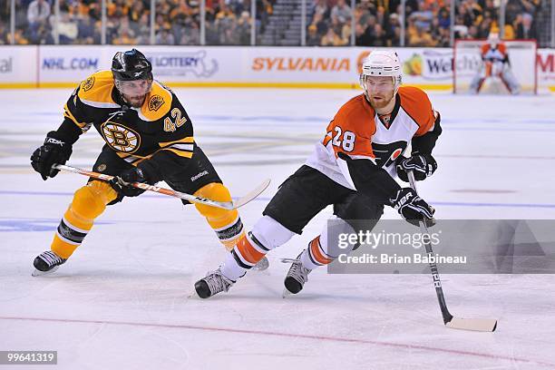 Claude Giroux of the Philadelphia Flyers skates with the puck against Trent Whitfield of the Boston Bruins in Game Seven of the Eastern Conference...
