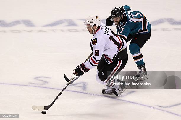 Jonathan Toews of the Chicago Blackhawks moves the puck in front of Torrey Mitchell of the San Jose Sharks in Game One of the Western Conference...