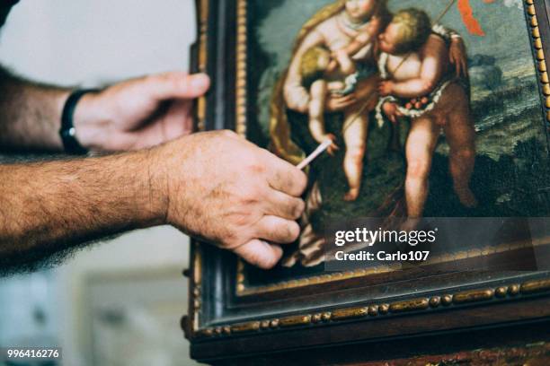 restoring an old painting - restaurar imagens e fotografias de stock