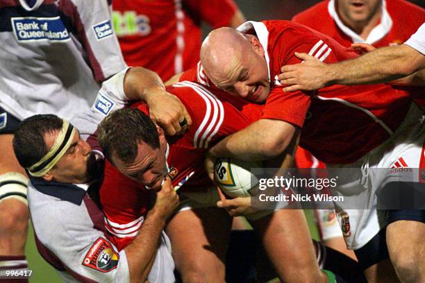 Flanker Richard Hill and hooker Keith Wood of the British Lions combine to drive against hooker Michael Foley of the Queensland Reds during the match...