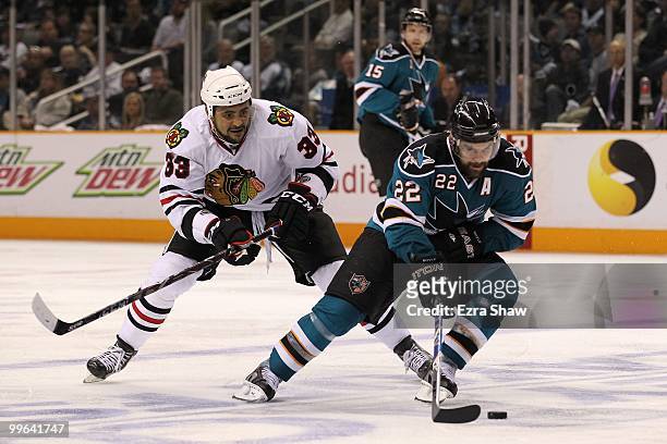 Dan Boyle of the San Jose Sharks moves the puck in front of Dustin Byfuglien of the Chicago Blackhawks in Game One of the Western Conference Finals...