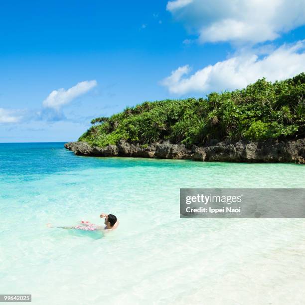 enjoying the clear blue tropical water of okinawa - ippei naoi fotografías e imágenes de stock