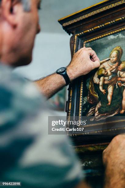 artist restoring an old painting - man in antique shop stock pictures, royalty-free photos & images