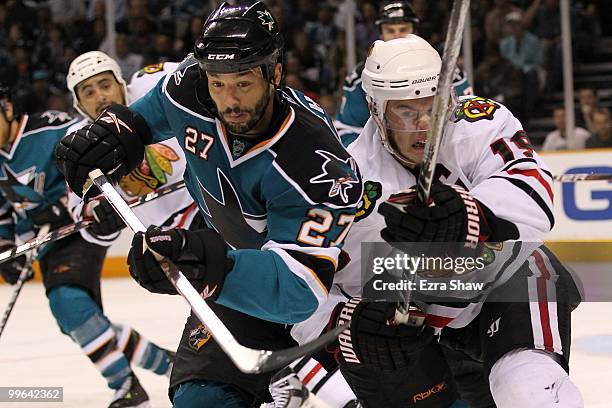 Manny Malhotra of the San Jose Sharks battles for the puck alongside Jonathan Toews of the Chicago Blackhawks in Game One of the Western Conference...