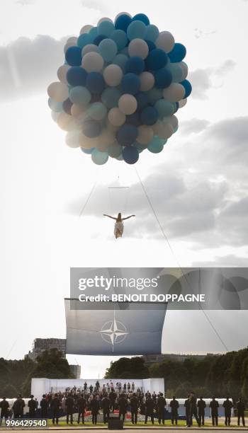 An acrobat performs a show ahead of a working dinner at The Parc du Cinquantenaire - Jubelpark Park in Brussels on July 11 during the North Atlantic...