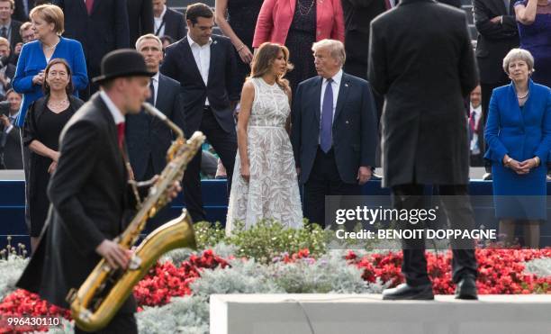 Musicians perform as First Lady of the US Melania Trump and US President Donald Trump speak to each other during a show after a dinner at the Parc du...