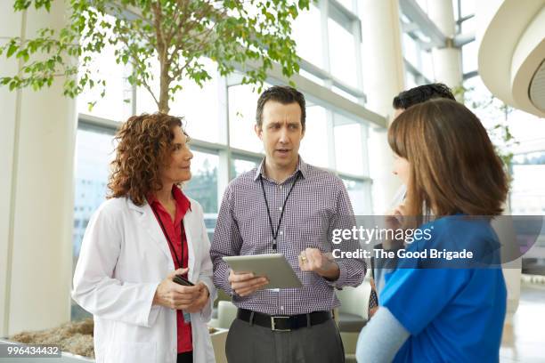 medical professionals having discussion in hospital lobby - administrator 個照片及圖片檔