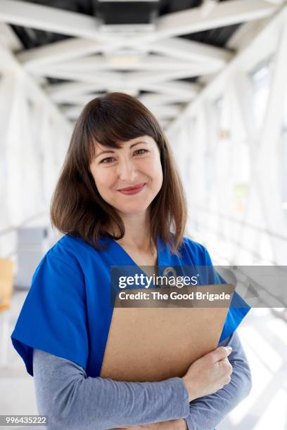 portrait of nurse standing in hospital corridor - hot nurse stock-fotos und bilder