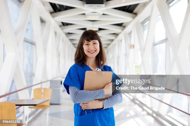 portrait of nurse standing in hospital corridor - hot nurse stock-fotos und bilder