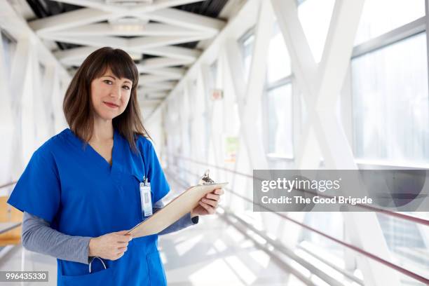 portrait of nurse standing in hospital corridor - hot nurse stock-fotos und bilder