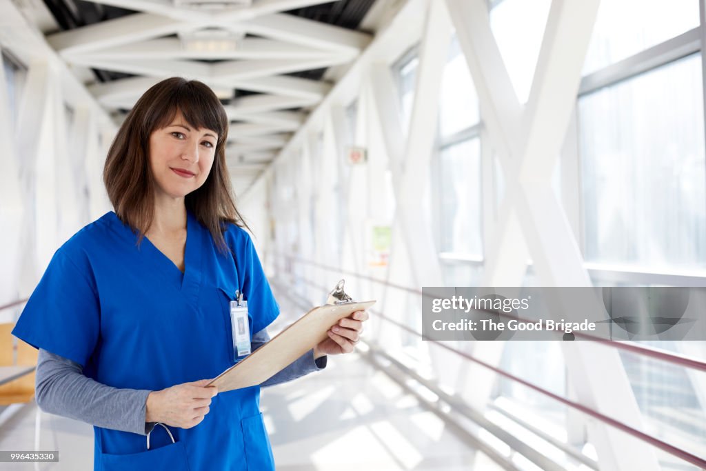 Portrait of nurse standing in hospital corridor