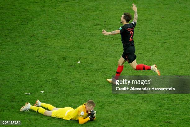 Jordan Pickford of England lies on the floor dejected as Sime Vrsaljko of Croatia celebrates winning the 2018 FIFA World Cup Russia Semi Final match...
