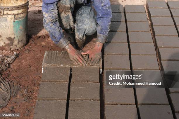 Worker makes bricks at a mud bricks factory on July 07, 2018 in north Sana’a, Yemen. A mudbrick or mud-brick is a brick which dates back thousands of...