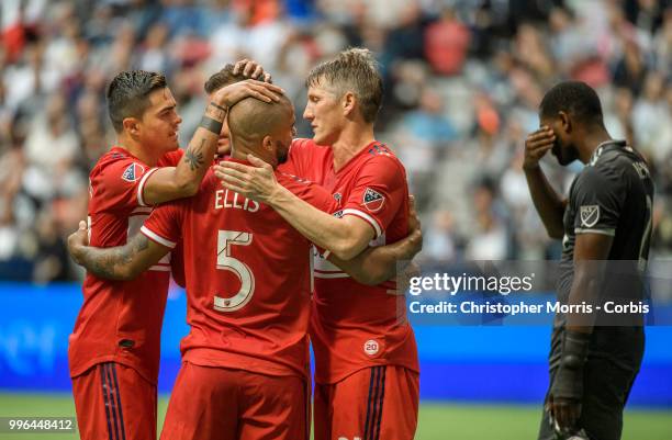 Diego Campos , Nemanja Nikolic , Kevin Ellis, and Bastian Schweinsteiger of the Chicago Fire celebrate a goal as Doneil Henry of the Vancouver...