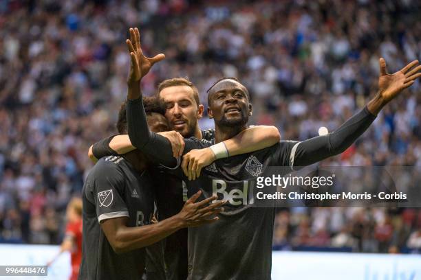 Alphonso Davies , Jordon Mutch and Kei Kamara of the Vancouver Whitecaps FC celebrate Kamara's goal against the Chicago Fire at BC Place on July 7,...