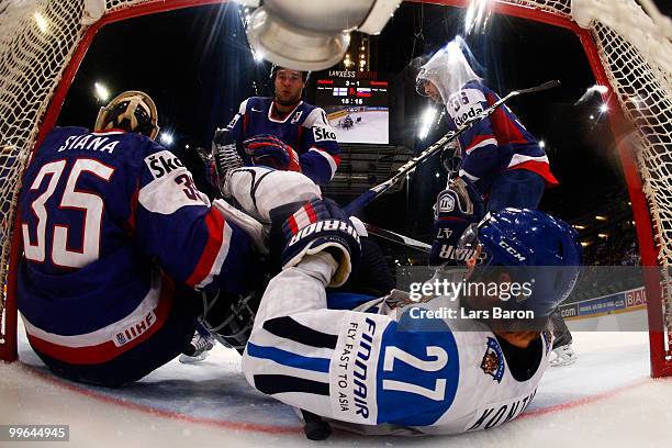 Petri Kontiola of Finland falls over goalie Rastislav Stana of Slovakia during the IIHF World Championship qualification round match between Finland...