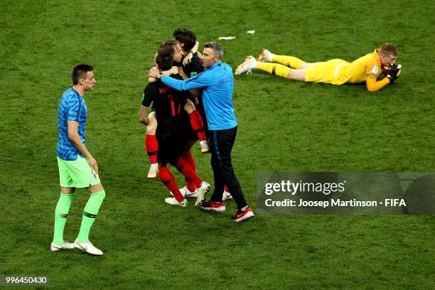 Jordan Pickford of England looks dejected as Croatia players celebrate following their sides victory in the 2018 FIFA World Cup Russia Semi Final...