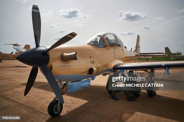 Two mechanics prearrange one of the four newly arrived turboprop light attack aircrafts "Super Tucano" at the military air base in Bamako on July 11,...