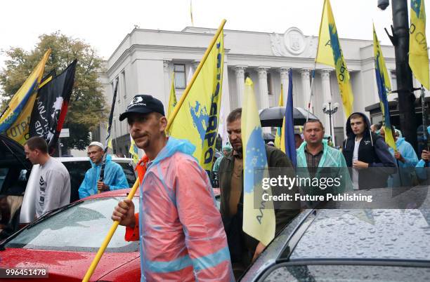 Demonstrators equipped with flags of the Avto Yevro Syla NGO block Hrushevskoho Street that runs through government quarters as they demand to adopt...