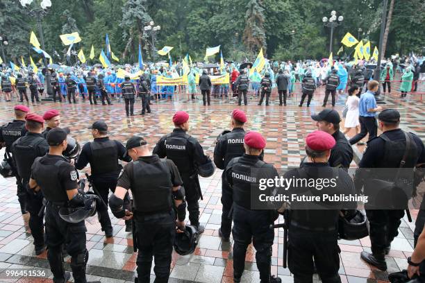 Police officers stand guard during a rally on for the adoption of a draft bill on customs clearance and lower tax incidence on used cars brought from...