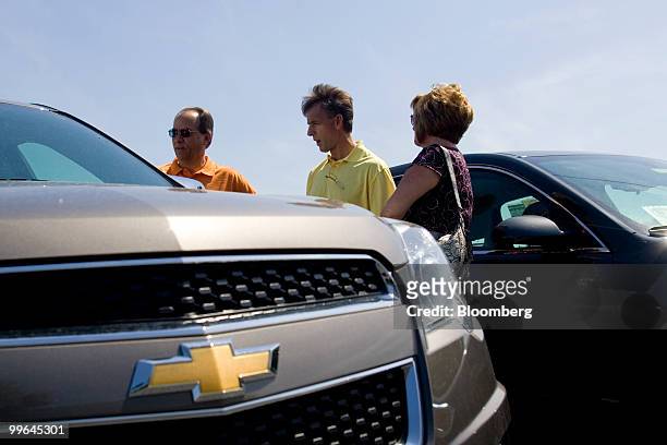 Sales associate Roger Wood, center, talks with Curtis and Pamela Carroll, as they look over a General Motors Co. 2010 Chevrolet Equinox at Bobby...
