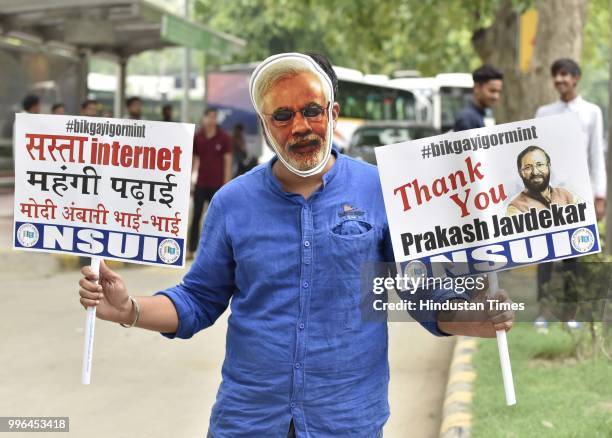 An activist from National Students' Union of India holds a placard during a protest against Narendra Modi for granting institute of eminence status...