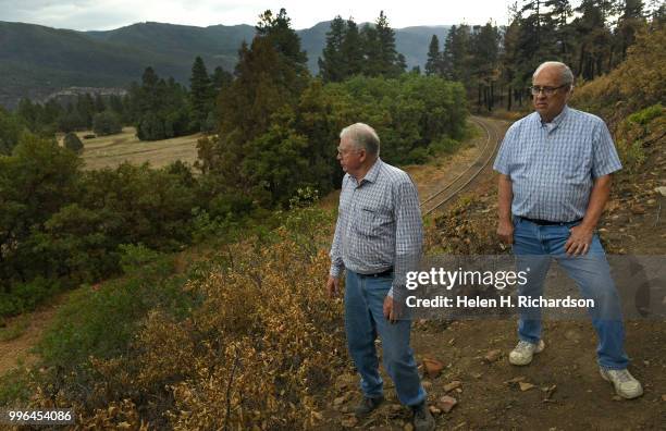 Neighbors Cres Fleming, left, and Al Chione, right, stand in the exact area where he says the 416 fire started on July 10, 2018 near Hermosa,...