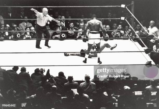 Sonny Liston stands over a fallen Floyd Patterson as referee Frank Sikora starts the count during the World Heavyweight Championship at Comiskey Park...