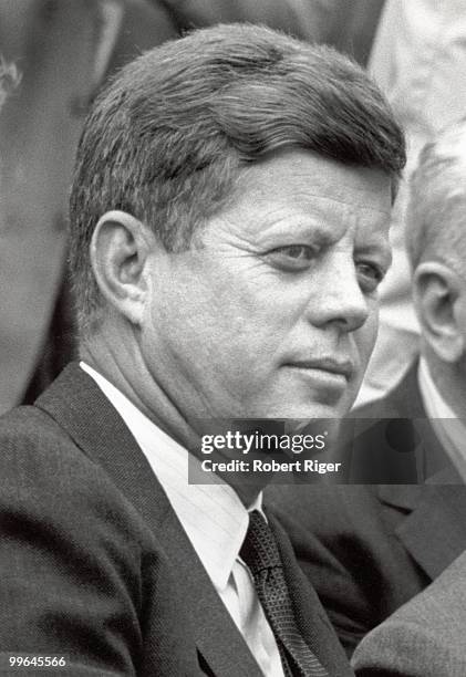 President John F. Kennedy watches the Opening Day game between the Washington Senators and Detroit Tigers at D.C. Stadium on April 9, 1962 in...