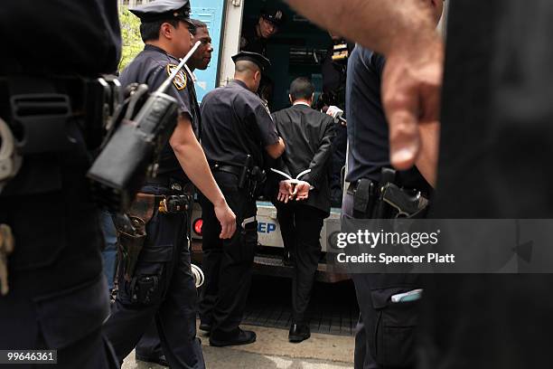 Man is lead into a police van during an act of civil disobedience to protest against the lack of an immigration reform bill on May 17, 2010 in New...
