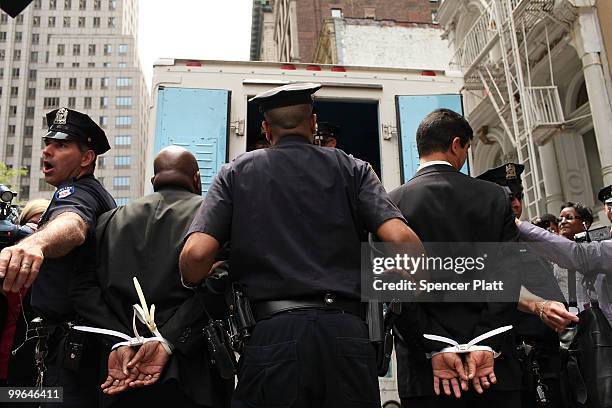 Two men are arrested lead into a police van during an act of civil disobedience to protest against the lack of an immigration reform bill on May 17,...