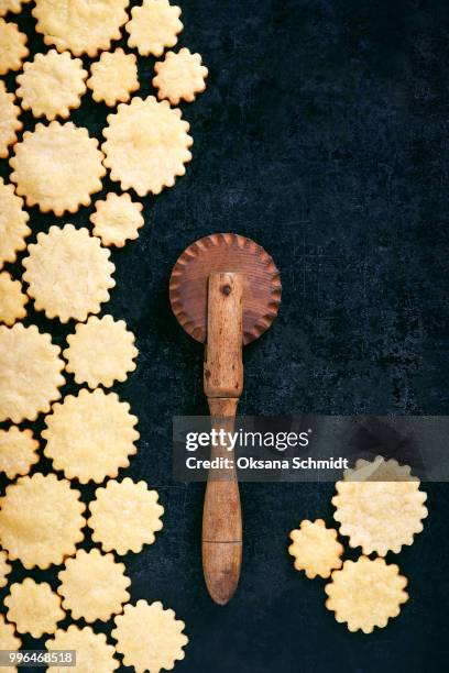 homemade butter cookies with old wooden sliced rolled dough. dark rustic style. creative food concept. - idee stock pictures, royalty-free photos & images