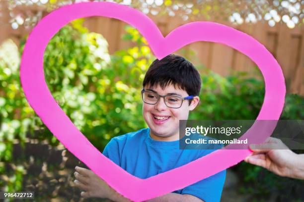 Portret van een jongen van het autistisch en syndroom van down in de vorm van een hart