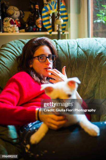 woman on the couch with a siberian husky - fiori stockfoto's en -beelden