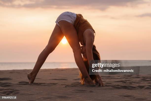 yoga au beau coucher de soleil au bord de la mer - mihailomilovanovic photos et images de collection