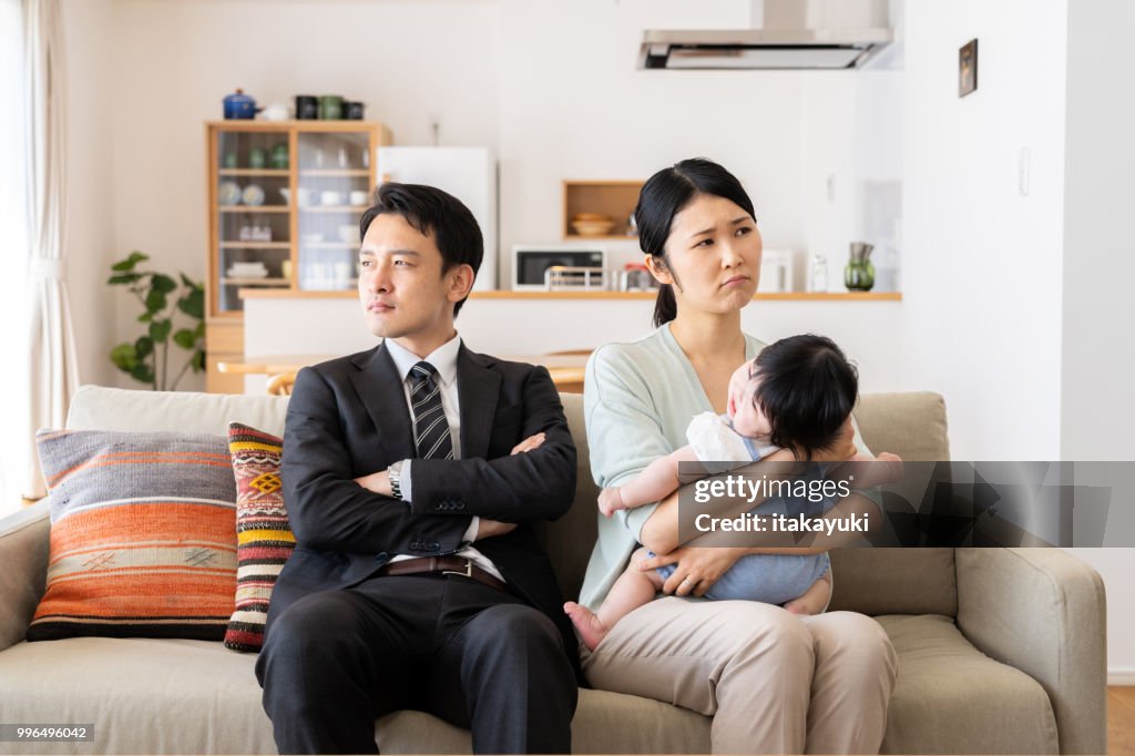 Jovem família asiática na sala de estar