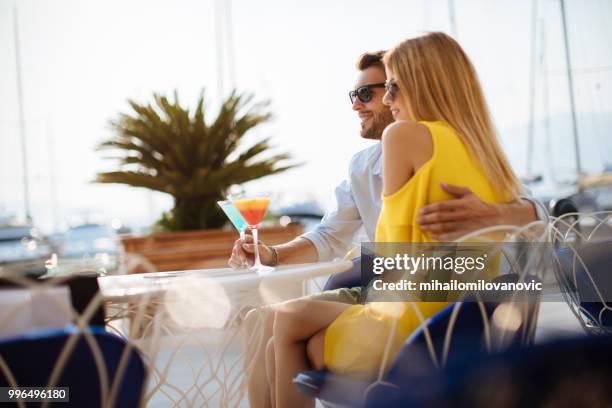 couple en dégustant des cocktails à l’extérieur dans un café - mihailomilovanovic photos et images de collection