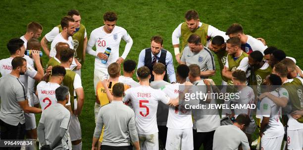 England's coach Gareth Southgate speaks to his players during extra time in the Russia 2018 World Cup semi-final football match between Croatia and...